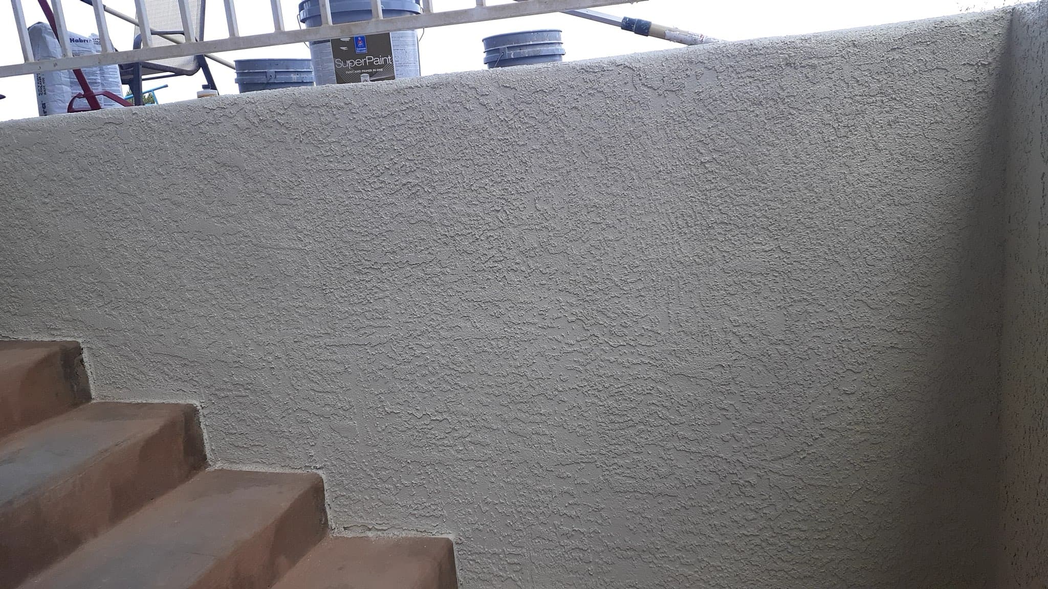 A stairwell wall repaired and repainted in a clean grey finish after water damage